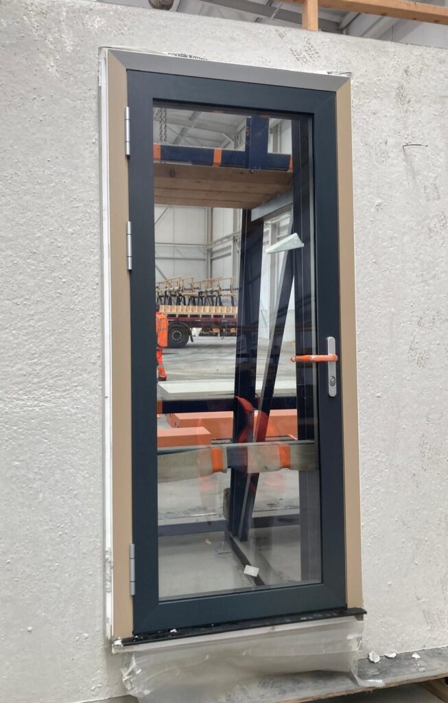 Een prefab aluminium kozijn dat direct is ingegoten in een betonnen prefabwand.